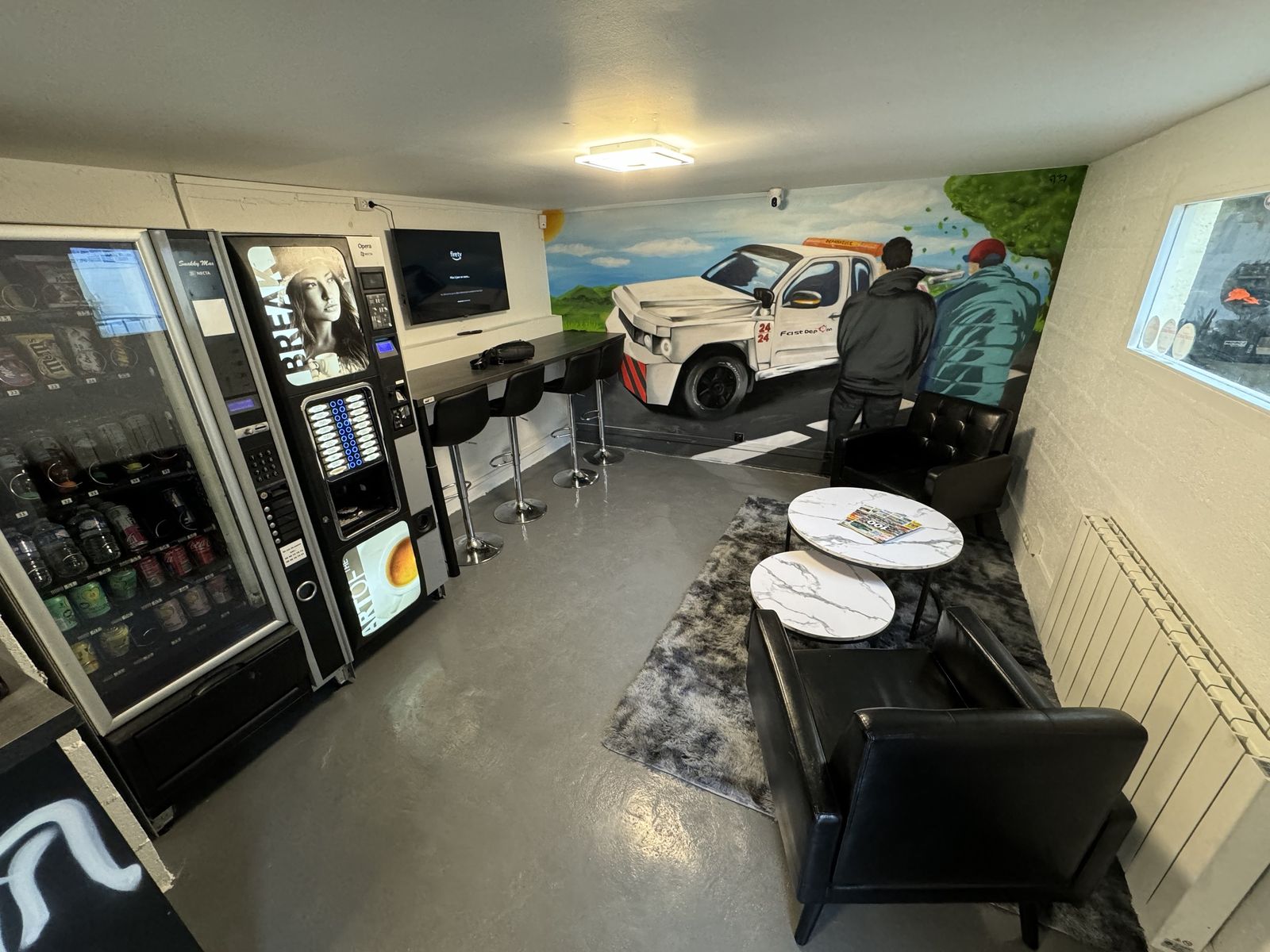 Salle d'attente avec fauteuils et machine à café